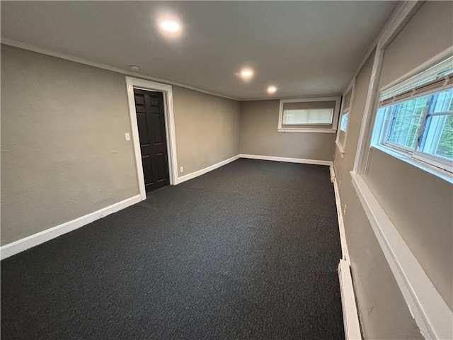 empty room featuring recessed lighting, baseboard heating, dark colored carpet, and baseboards