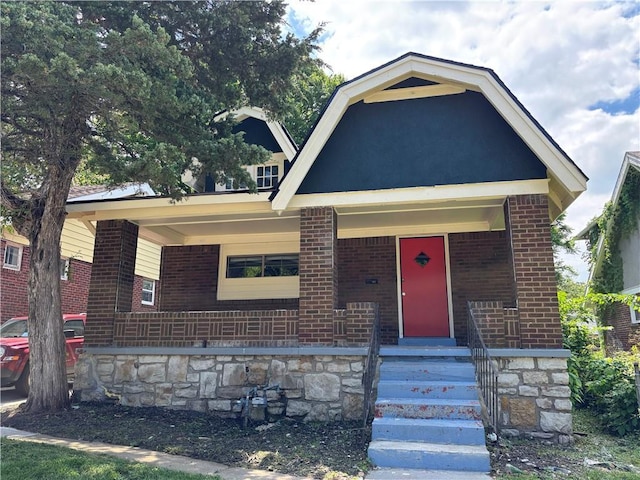 view of front of house with brick siding and a porch
