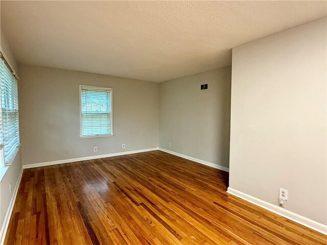 406 Bowen St, Linwood, KS 66052 - spare room featuring wood finished floors, baseboards, and a textured ceiling