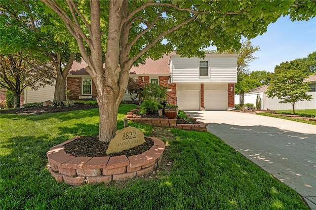 8822 Hadley St, Overland Park, KS 66212 - tri-level home featuring brick siding, concrete driveway, an attached garage, and a front lawn
