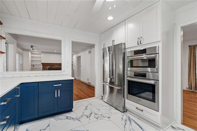 8822 Hadley St, Overland Park, KS 66212 - kitchen featuring stainless steel appliances, blue cabinets, light marble finish flooring, white cabinets, and light countertops