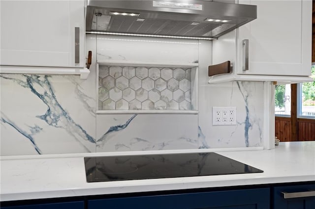 8822 Hadley St, Overland Park, KS 66212 - kitchen featuring exhaust hood, blue cabinets, black electric stovetop, and white cabinetry