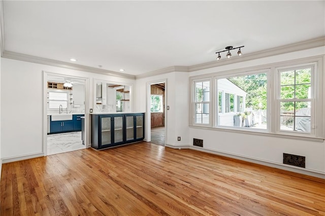 8822 Hadley St, Overland Park, KS 66212 - unfurnished living room featuring ornamental molding and light wood-style floors