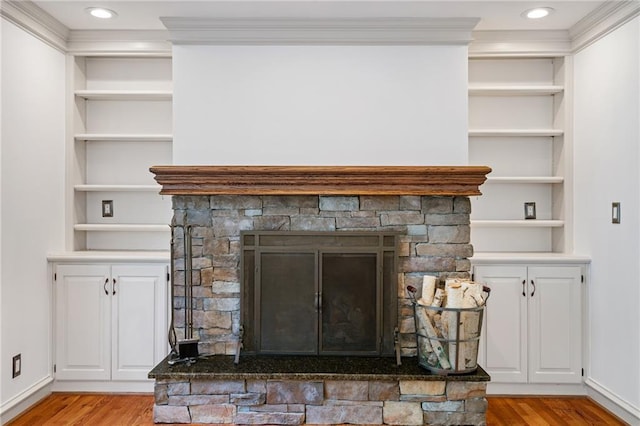 8822 Hadley St, Overland Park, KS 66212 - detailed view of wood finished floors, a stone fireplace, built in features, and crown molding