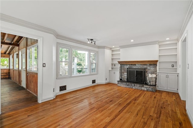 8822 Hadley St, Overland Park, KS 66212 - unfurnished living room with light wood-style floors, a stone fireplace, crown molding, built in shelves, and recessed lighting