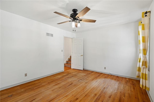 8822 Hadley St, Overland Park, KS 66212 - spare room with light wood finished floors, stairs, and ceiling fan