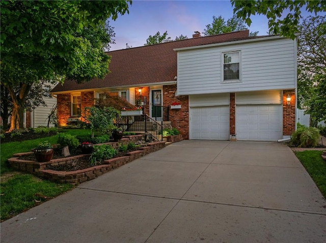 8822 Hadley St, Overland Park, KS 66212 - split level home with brick siding, an attached garage, driveway, and a chimney