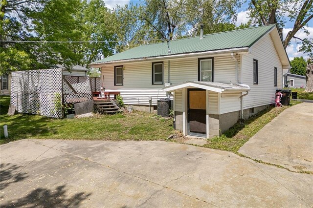 906 W Pearl St, Savannah, MO 64485 - back of house with metal roof, central AC, a deck, and a lawn