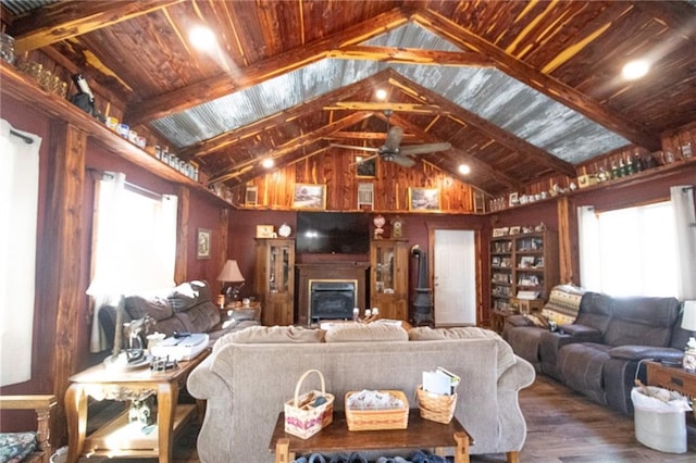 living room with lofted ceiling, a ceiling fan, wood finished floors, and a glass covered fireplace