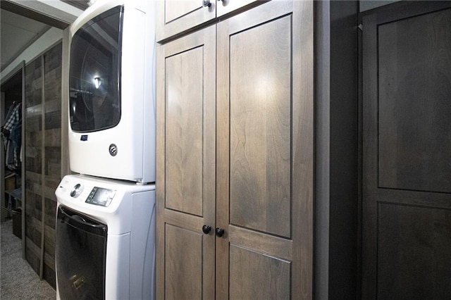 laundry room featuring cabinet space, estacked washer and dryer, and carpet flooring