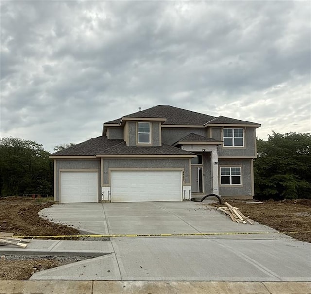 8913 N Colorado Ave, Kansas City, MO 64156 - view of front facade with driveway, an attached garage, stucco siding, and a shingled roof