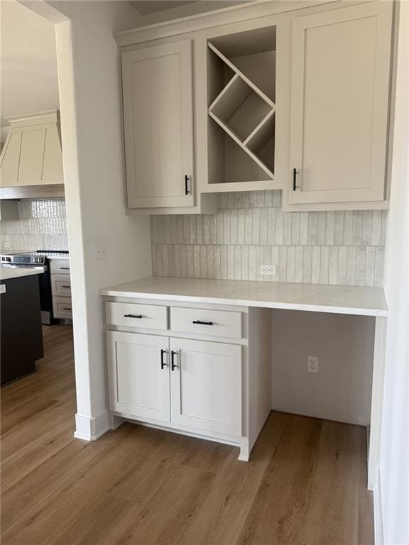 8913 N Colorado Ave, Kansas City, MO 64156 - bar featuring custom range hood, backsplash, wood finished floors, and stainless steel range