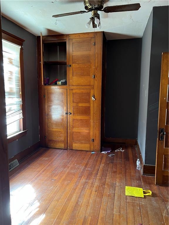 206 W 4th St, Norborne, MO 64668 - unfurnished bedroom with light wood finished floors, baseboards, and a ceiling fan