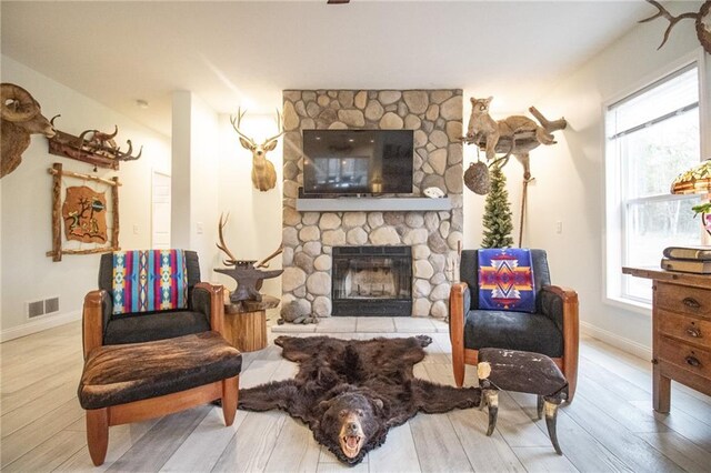 10200 SE 1075th Rd, Collins, MO 64738 - sitting room featuring a stone fireplace, wood finished floors, and plenty of natural light