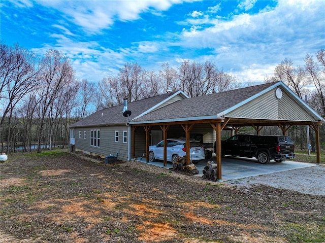 10200 SE 1075th Rd, Collins, MO 64738 - view of property exterior featuring roof with shingles, a carport, and dirt driveway