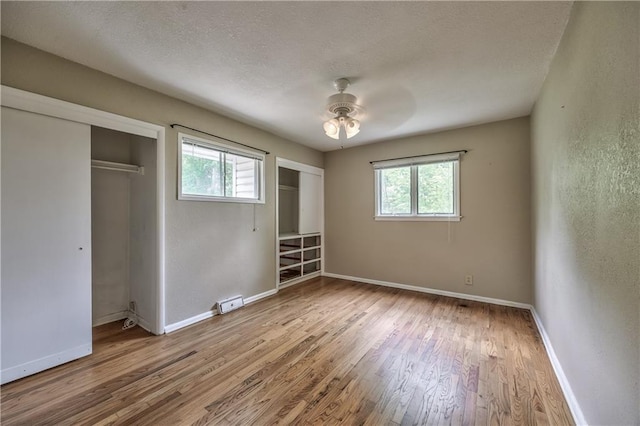 4306 W 78th Ter, Prairie Village, KS 66208 - unfurnished bedroom with multiple windows, wood finished floors, baseboards, and a textured ceiling
