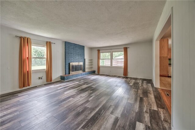 4306 W 78th Ter, Prairie Village, KS 66208 - unfurnished living room with wood finished floors, a textured ceiling, and a fireplace