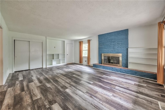 4306 W 78th Ter, Prairie Village, KS 66208 - unfurnished living room featuring a textured ceiling, wood finished floors, a brick fireplace, and built in shelves