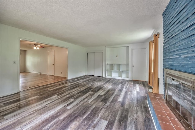 4306 W 78th Ter, Prairie Village, KS 66208 - unfurnished living room featuring wood finished floors, a textured ceiling, a fireplace, ceiling fan, and baseboards