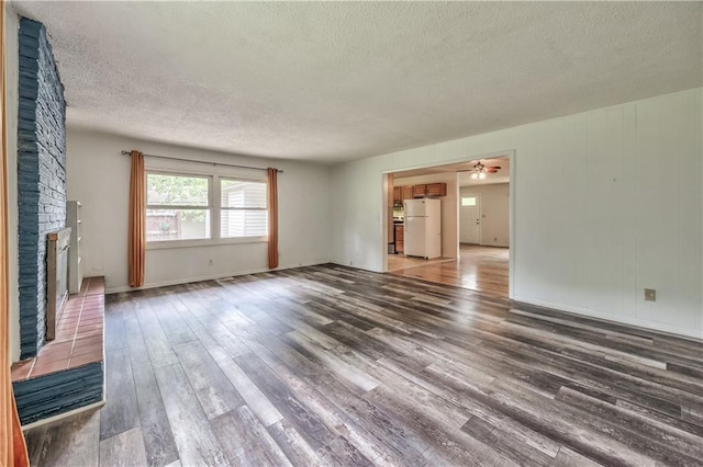 4306 W 78th Ter, Prairie Village, KS 66208 - unfurnished living room with a textured ceiling, a brick fireplace, wood finished floors, and ceiling fan