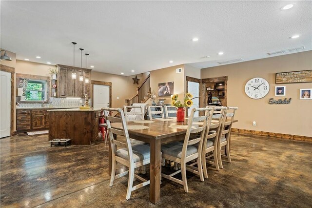 dining room featuring finished concrete flooring, recessed lighting, stairway, baseboards, and a textured ceiling