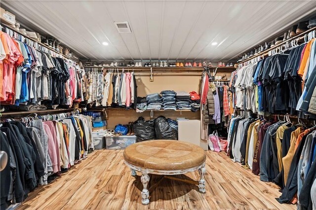 walk in closet with wood finished floors