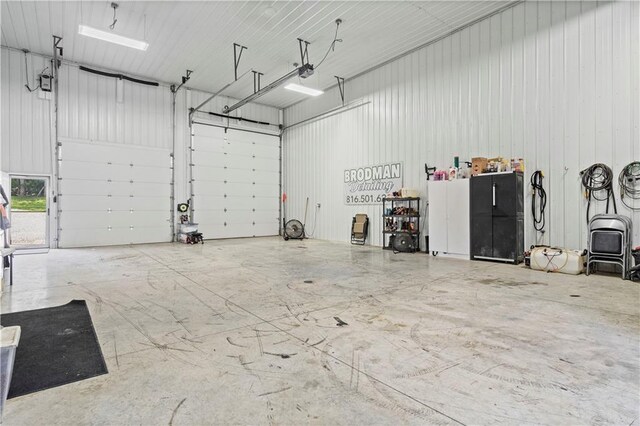garage with a garage door opener and metal wall
