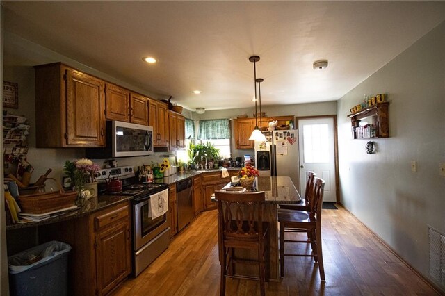 10875 SE 54th Hwy, Collins, MO 64738 - kitchen featuring stainless steel appliances, light wood-style floors, a kitchen breakfast bar, decorative light fixtures, and recessed lighting