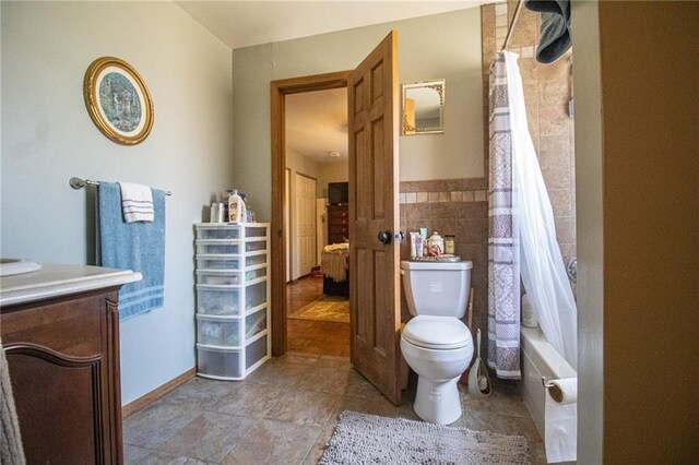 10875 SE 54th Hwy, Collins, MO 64738 - bathroom with toilet, tile walls, shower / bath combo with shower curtain, and vanity