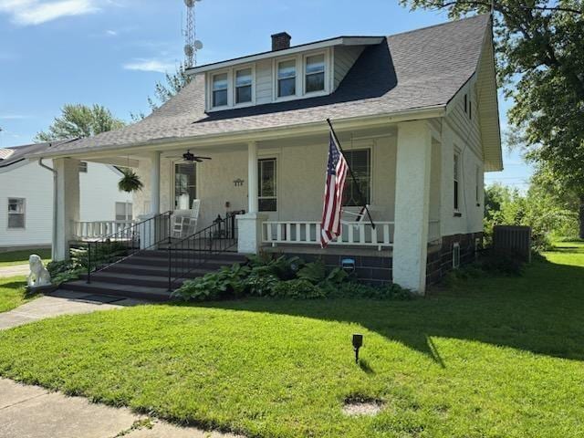 bungalow-style house featuring a porch, a chimney, a front lawn, stucco siding, and central air condition unit