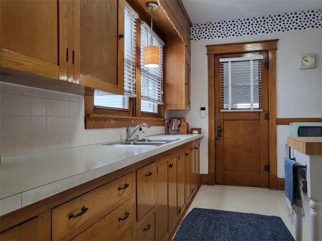 kitchen featuring a sink, light countertops, and brown cabinets