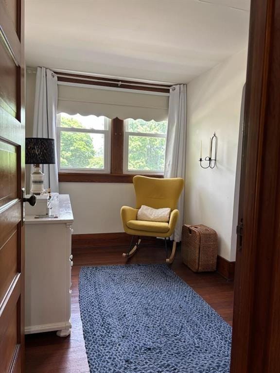 sitting room with dark wood finished floors and baseboards