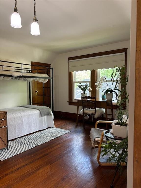 bedroom featuring lofted ceiling, wood finished floors, and baseboards