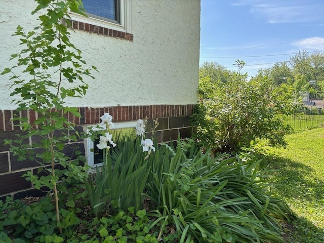 view of home's exterior featuring stucco siding and fence