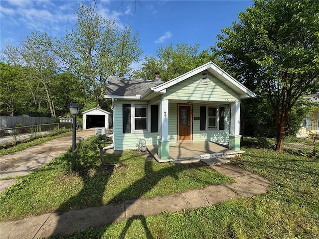 2544 S Overton Ave, Independence, MO 64052 - bungalow-style home featuring driveway, a porch, fence, an outbuilding, and a detached garage