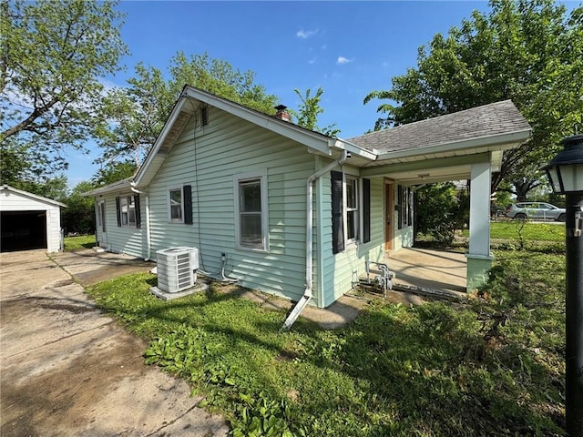 2544 S Overton Ave, Independence, MO 64052 - view of home's exterior with central air condition unit, an outdoor structure, a chimney, and a garage