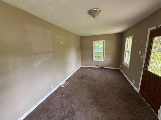 2544 S Overton Ave, Independence, MO 64052 - spare room featuring baseboards, a textured ceiling, and dark carpet
