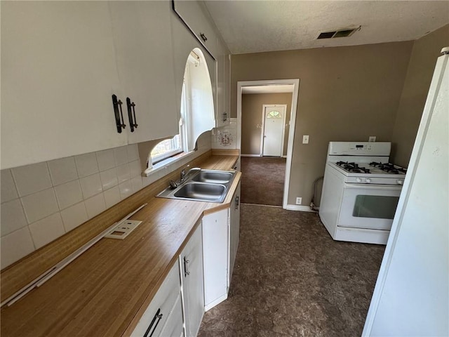 2544 S Overton Ave, Independence, MO 64052 - kitchen with white range with gas stovetop, a sink, white cabinets, wooden counters, and decorative backsplash