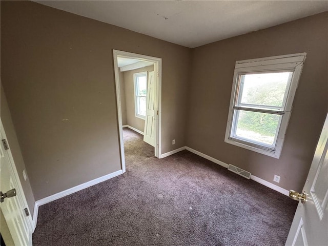 2544 S Overton Ave, Independence, MO 64052 - empty room featuring plenty of natural light, dark colored carpet, and baseboards