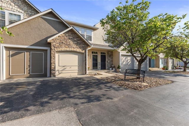 14037 W 112th Ter, Olathe, KS 66062 - view of front facade featuring stone siding, stucco siding, driveway, and a garage