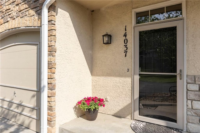 14037 W 112th Ter, Olathe, KS 66062 - doorway to property with stucco siding and stone siding