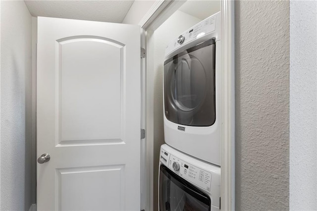 14037 W 112th Ter, Olathe, KS 66062 - laundry area featuring stacked washer / drying machine and a textured wall
