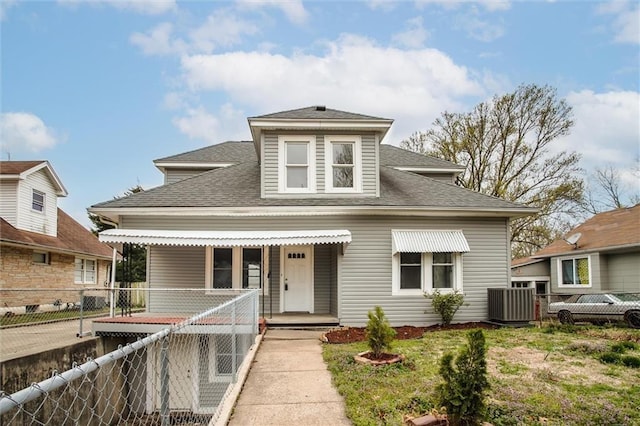 628 S Huttig Ave, Independence, MO 64053 - bungalow-style home featuring roof with shingles, central AC unit, a fenced front yard, and covered porch