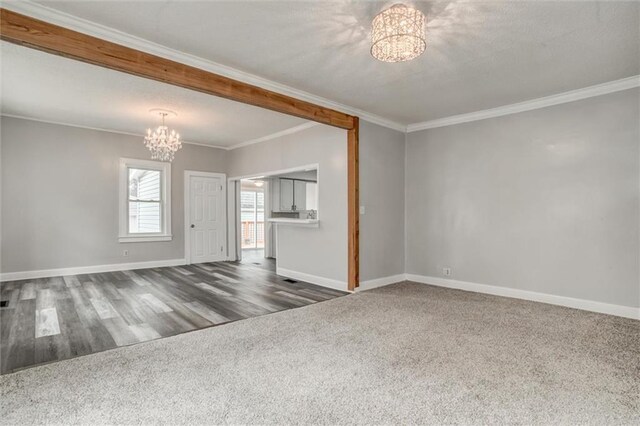 628 S Huttig Ave, Independence, MO 64053 - unfurnished living room with a chandelier, crown molding, carpet floors, and baseboards