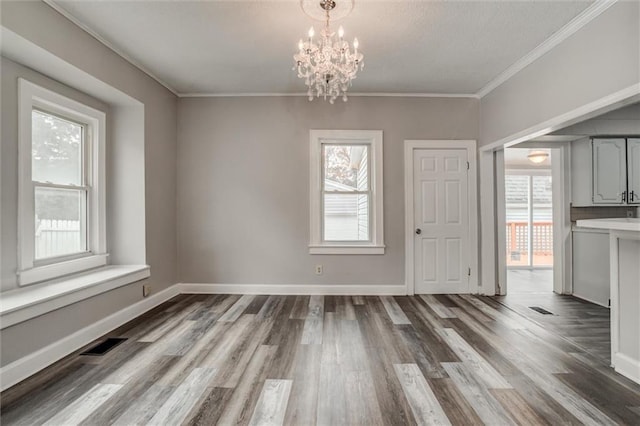 628 S Huttig Ave, Independence, MO 64053 - unfurnished dining area with plenty of natural light, a chandelier, wood finished floors, ornamental molding, and baseboards