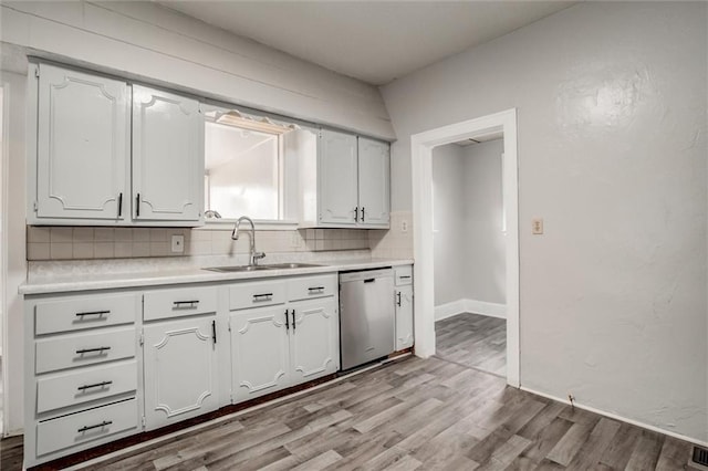 628 S Huttig Ave, Independence, MO 64053 - kitchen with dishwasher, a sink, backsplash, wood finished floors, and light countertops