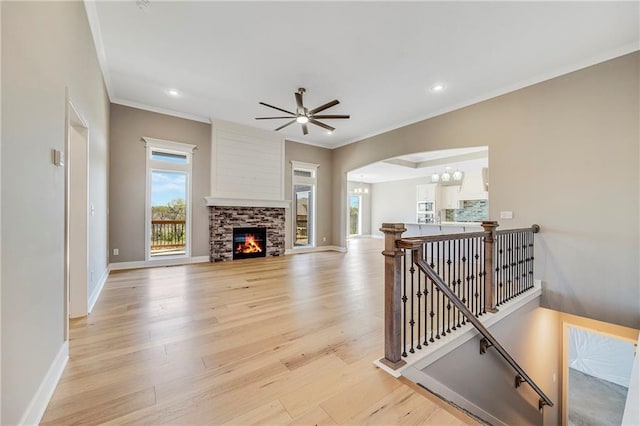 10201 N Winchester Ave, Kansas City, MO 64156 - living room featuring crown molding, arched walkways, light wood-style flooring, baseboards, and a ceiling fan