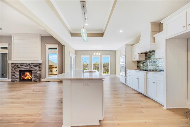 10201 N Winchester Ave, Kansas City, MO 64156 - kitchen featuring a sink, white appliances, light wood-style flooring, a kitchen island with sink, and recessed lighting