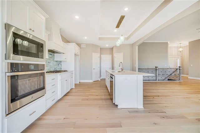 10201 N Winchester Ave, Kansas City, MO 64156 - kitchen with stainless steel appliances, a sink, white cabinets, light countertops, and ornamental molding