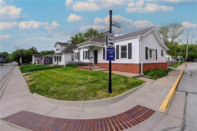 view of front facade featuring a front yard and brick siding